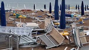 Lettini e sdraio accumulati e danneggiati dal vento sulla spiaggia di Lignano