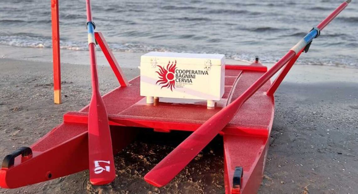 Un moscone di salvataggio rosso della Cooperativa Bagnini Cervia posizionato sulla battigia di fronte al mare.