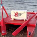 Un moscone di salvataggio rosso della Cooperativa Bagnini Cervia posizionato sulla battigia di fronte al mare.