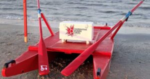 Un moscone di salvataggio rosso della Cooperativa Bagnini Cervia posizionato sulla battigia di fronte al mare.