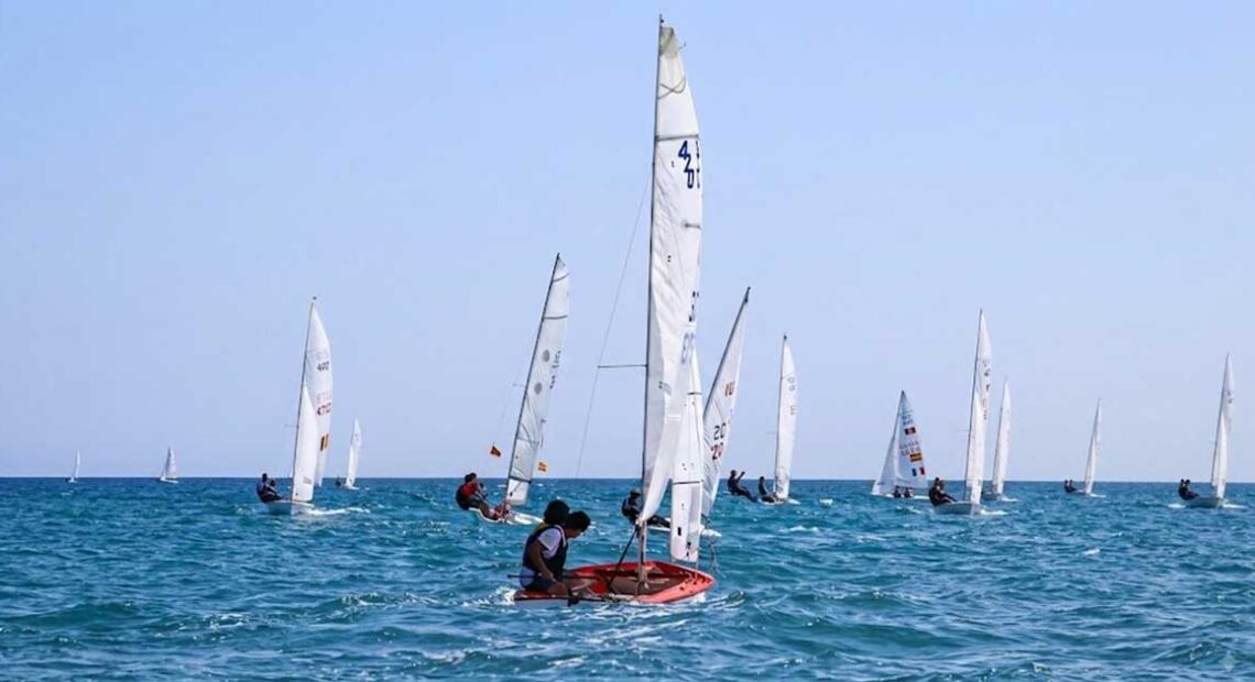 Flotta di imbarcazioni a vela e derive in gara sul mare davanti alla costa durante la Prosecco's Cup