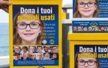 Contenitori gialli della raccolta occhiali usati del Lions Club posizionati presso uno stabilimento balneare.