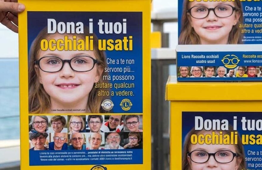 Contenitori gialli della raccolta occhiali usati del Lions Club posizionati presso uno stabilimento balneare.