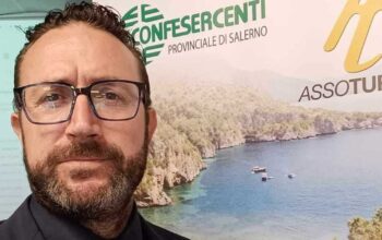 Raffaele Esposito, presidente di Fiba Confesercenti Campania, davanti a un banner istituzionale.