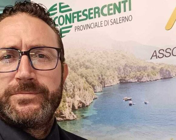 Raffaele Esposito, presidente di Fiba Confesercenti Campania, davanti a un banner istituzionale.