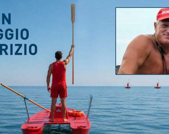 Bagnino su pattino di salvataggio alza un remo verso il cielo in segno di rispetto, con un ritratto di Fabrizio Valente e la scritta "BUON VIAGGIO FABRIZIO".