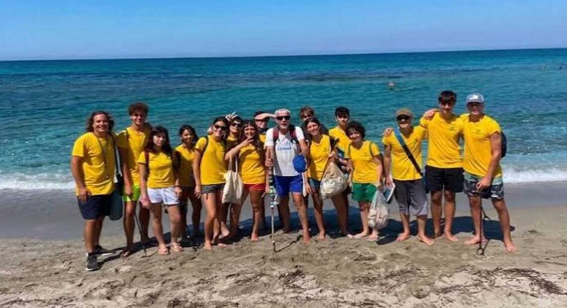 I giovani volontari del progetto Sentinelle del Sinis in maglietta gialla sulla spiaggia di Cabras.