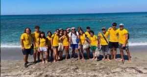 I giovani volontari del progetto Sentinelle del Sinis in maglietta gialla sulla spiaggia di Cabras.