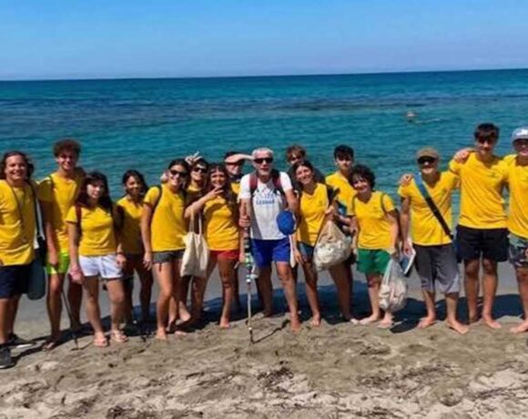 I giovani volontari del progetto Sentinelle del Sinis in maglietta gialla sulla spiaggia di Cabras.