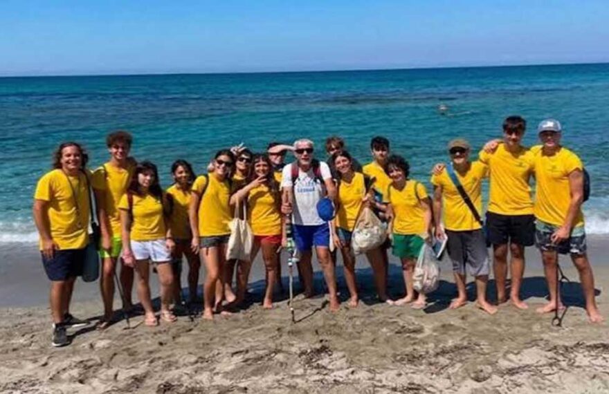 I giovani volontari del progetto Sentinelle del Sinis in maglietta gialla sulla spiaggia di Cabras.
