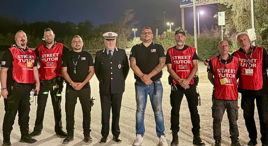 Un gruppo di operatori del servizio Street Tutor in pettorina rossa insieme a un ufficiale della Polizia locale nei Lidi di Comacchio