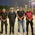 Un gruppo di operatori del servizio Street Tutor in pettorina rossa insieme a un ufficiale della Polizia locale nei Lidi di Comacchio
