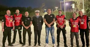 Un gruppo di operatori del servizio Street Tutor in pettorina rossa insieme a un ufficiale della Polizia locale nei Lidi di Comacchio