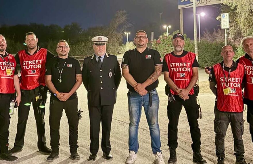 Un gruppo di operatori del servizio Street Tutor in pettorina rossa insieme a un ufficiale della Polizia locale nei Lidi di Comacchio