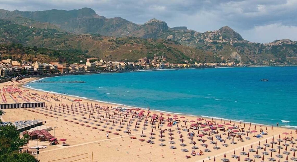 Veduta aerea del litorale e degli stabilimenti balneari di Giardini Naxos con ombrelloni e mare