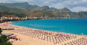 Veduta aerea del litorale e degli stabilimenti balneari di Giardini Naxos con ombrelloni e mare