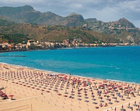 Veduta aerea del litorale e degli stabilimenti balneari di Giardini Naxos con ombrelloni e mare