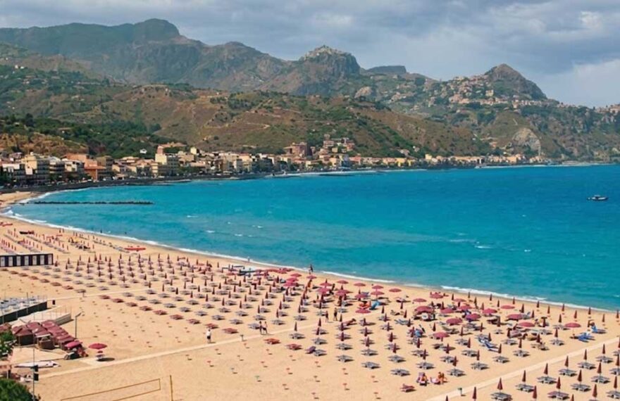Veduta aerea del litorale e degli stabilimenti balneari di Giardini Naxos con ombrelloni e mare