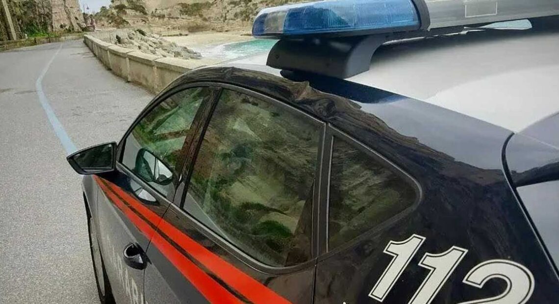 Un'auto dei Carabinieri in pattugliamento lungo la costa del Vibonese, sullo sfondo del promontorio di Tropea.