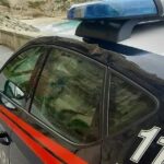Un'auto dei Carabinieri in pattugliamento lungo la costa del Vibonese, sullo sfondo del promontorio di Tropea.