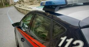 Un'auto dei Carabinieri in pattugliamento lungo la costa del Vibonese, sullo sfondo del promontorio di Tropea.