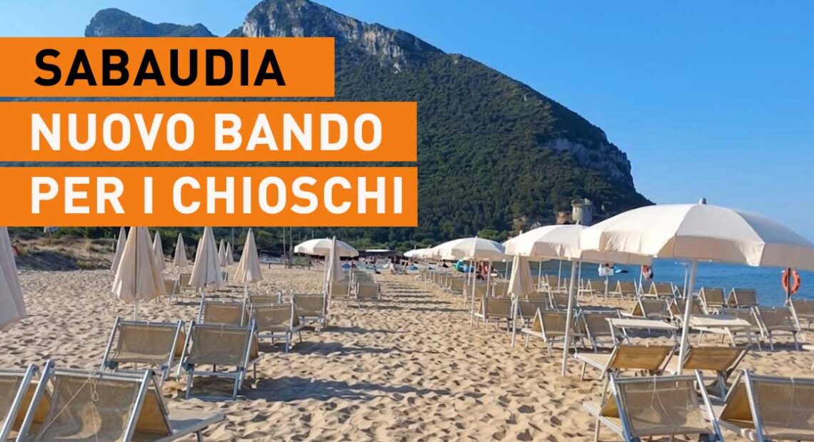 Spiaggia di Sabaudia con lettini, ombrelloni e il promontorio del Circeo sullo sfondo.