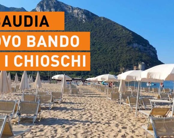 Spiaggia di Sabaudia con lettini, ombrelloni e il promontorio del Circeo sullo sfondo.