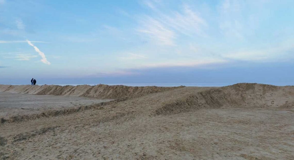 Grande duna di sabbia eretta sulla spiaggia di Ravenna come barriera di protezione contro le mareggiate invernali.