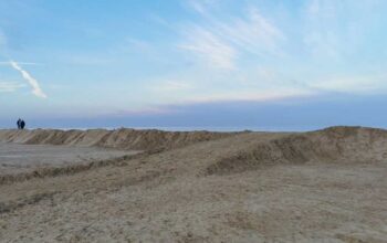 Grande duna di sabbia eretta sulla spiaggia di Ravenna come barriera di protezione contro le mareggiate invernali.