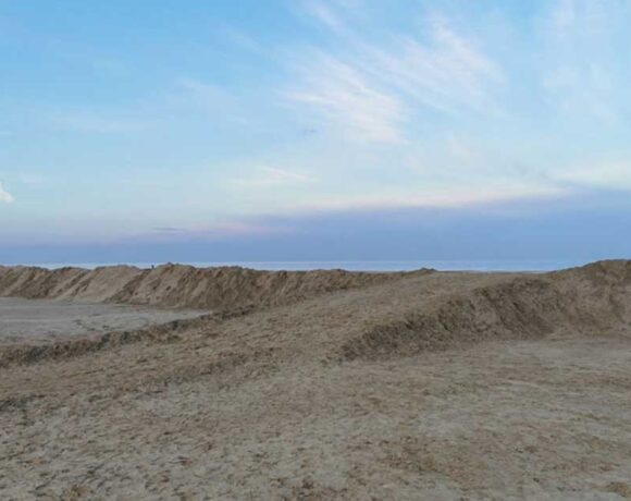Grande duna di sabbia eretta sulla spiaggia di Ravenna come barriera di protezione contro le mareggiate invernali.