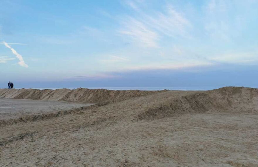 Grande duna di sabbia eretta sulla spiaggia di Ravenna come barriera di protezione contro le mareggiate invernali.