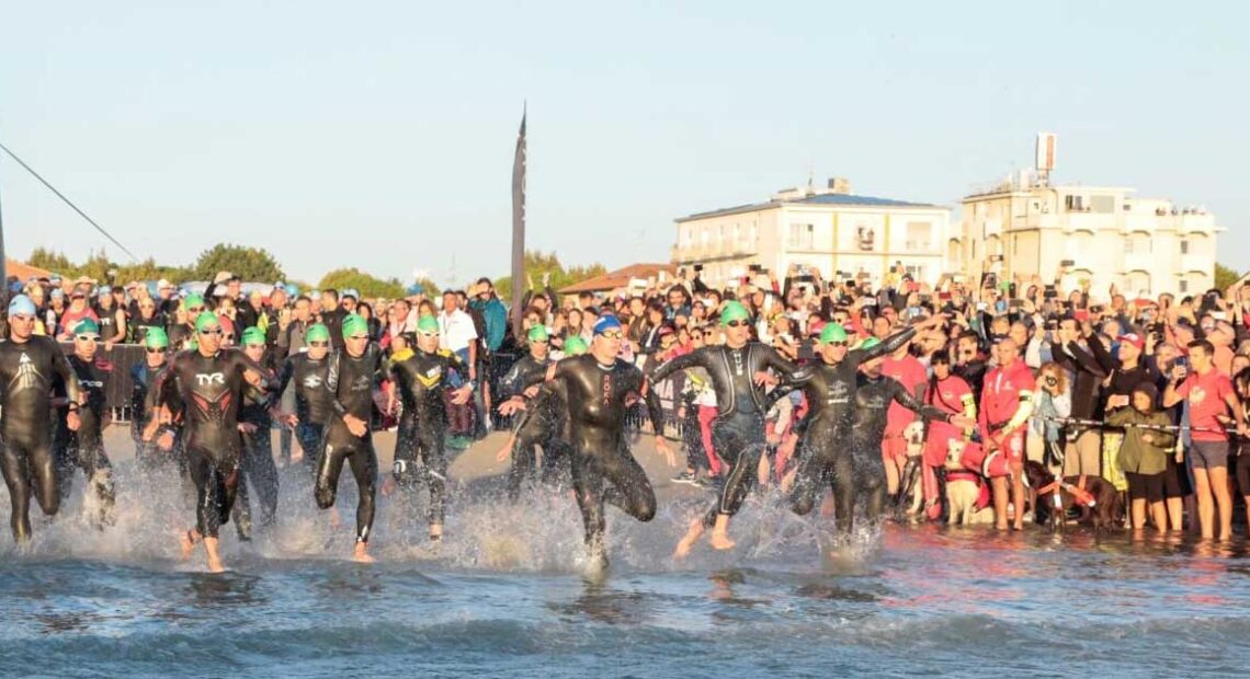 Atleti dell'Ironman in corsa verso il mare per la prova di nuoto sulla spiaggia di Cervia