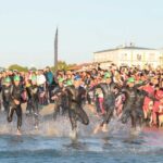 Atleti dell'Ironman in corsa verso il mare per la prova di nuoto sulla spiaggia di Cervia