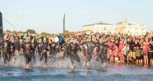 Atleti dell'Ironman in corsa verso il mare per la prova di nuoto sulla spiaggia di Cervia