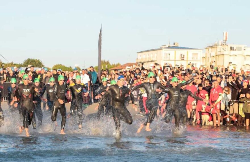 Atleti dell'Ironman in corsa verso il mare per la prova di nuoto sulla spiaggia di Cervia