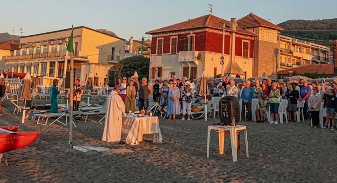 Celebrazione della messa all'alba sulla spiaggia dei Bagni San Pietro a Borgio Verezzi con numerosi fedeli presenti.