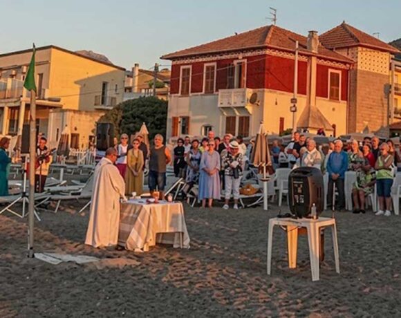 Celebrazione della messa all'alba sulla spiaggia dei Bagni San Pietro a Borgio Verezzi con numerosi fedeli presenti.
