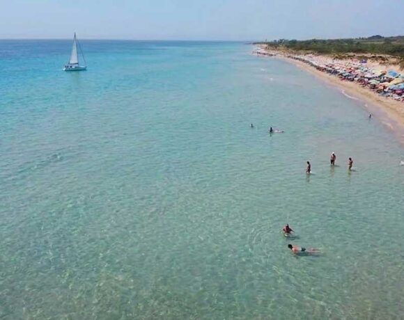 Veduta aerea della spiaggia libera di Pescoluse affollata di bagnanti e ombrelloni