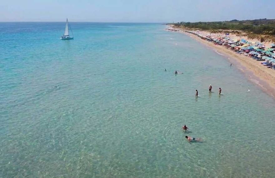 Veduta aerea della spiaggia libera di Pescoluse affollata di bagnanti e ombrelloni