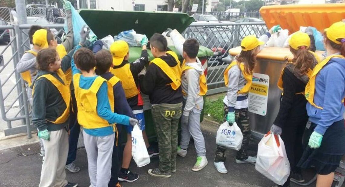 Studenti e volontari con pettorine gialle e guanti impegnati nella raccolta differenziata dei rifiuti a Bellaria Igea Marina.