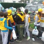 Studenti e volontari con pettorine gialle e guanti impegnati nella raccolta differenziata dei rifiuti a Bellaria Igea Marina.