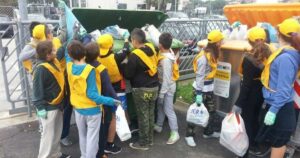 Studenti e volontari con pettorine gialle e guanti impegnati nella raccolta differenziata dei rifiuti a Bellaria Igea Marina.