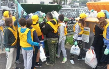 Studenti e volontari con pettorine gialle e guanti impegnati nella raccolta differenziata dei rifiuti a Bellaria Igea Marina.