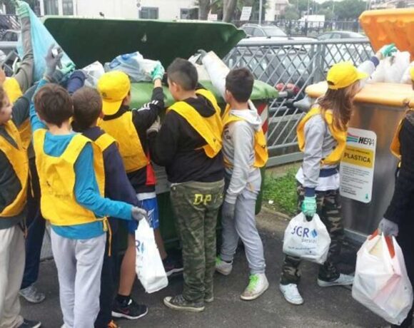 Studenti e volontari con pettorine gialle e guanti impegnati nella raccolta differenziata dei rifiuti a Bellaria Igea Marina.