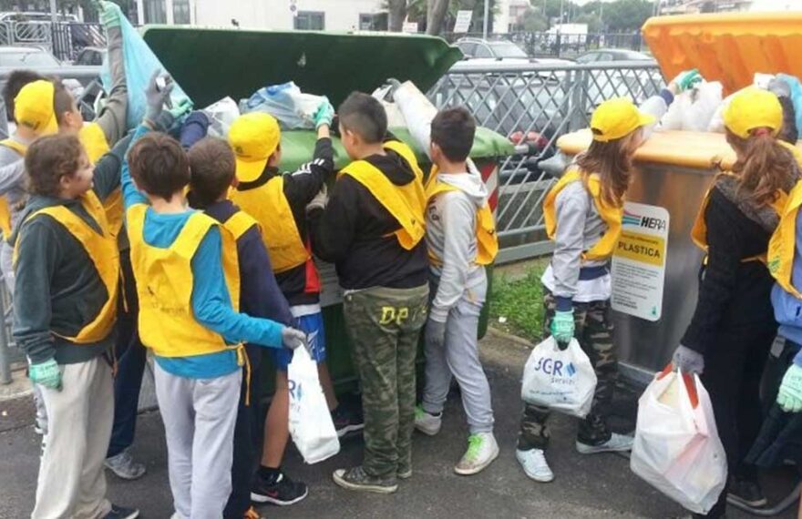 Studenti e volontari con pettorine gialle e guanti impegnati nella raccolta differenziata dei rifiuti a Bellaria Igea Marina.
