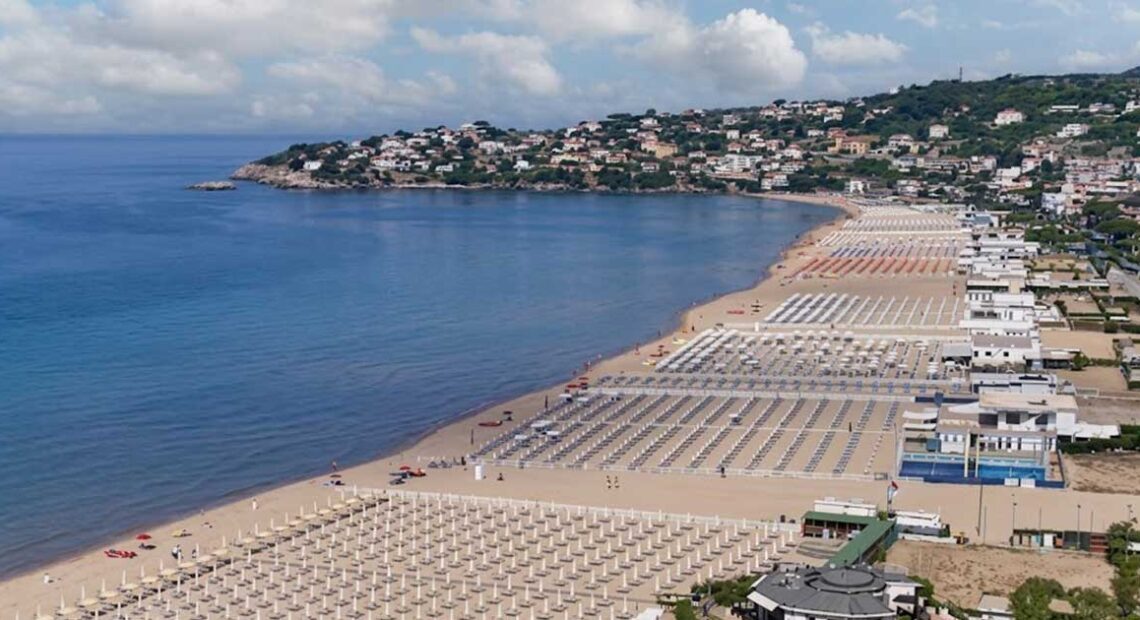 Vista panoramica dall'alto della spiaggia di Serapo a Gaeta con stabilimenti balneari e ombrelloni disposti lungo la costa