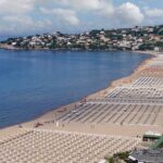 Vista panoramica dall'alto della spiaggia di Serapo a Gaeta con stabilimenti balneari e ombrelloni disposti lungo la costa