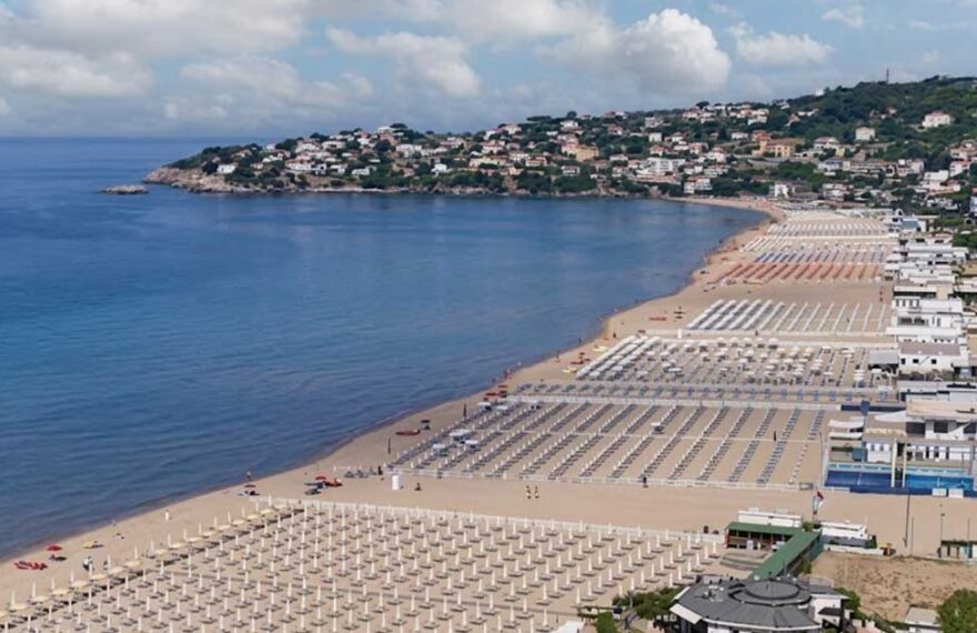 Vista panoramica dall'alto della spiaggia di Serapo a Gaeta con stabilimenti balneari e ombrelloni disposti lungo la costa
