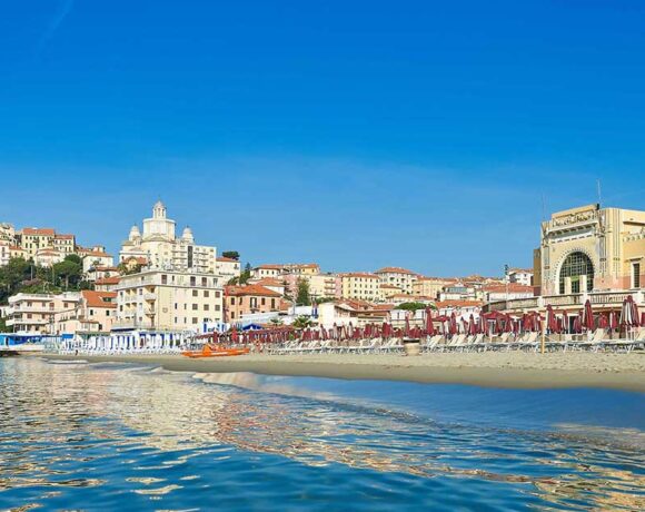 Stabilimento balneare sulla spiaggia di Imperia con lo sfondo di Porto Maurizio