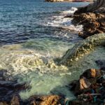 Sversamento di acque reflue e inquinanti in mare da un tubo sulla costa.